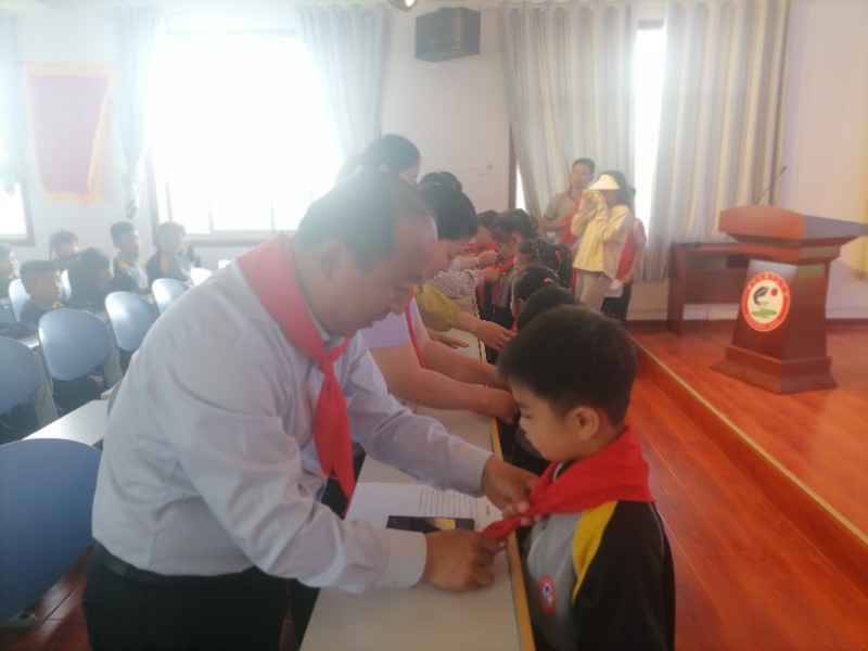 图1：6月2日，顾官屯镇中心小学举行少先队入队仪式，校长毕建勇为新队员佩戴红领巾.jpg