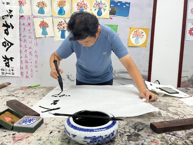 图2.1：7月4日，顾官屯镇中心小学开展市直书画家协会进校园活动，书画协会成员正在创作.jpg
