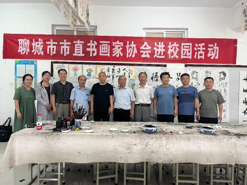 图1：7月4日，顾官屯镇中心小学开展市直书画家协会进校园活动，顾官屯镇中心小学校长毕建勇同书画家协会成员合影.jpg
