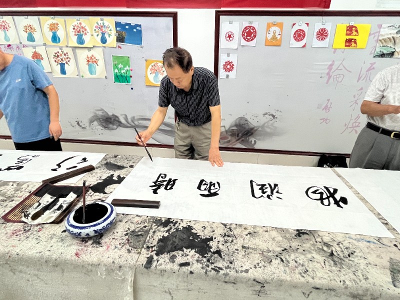 图2.2：7月4日，顾官屯镇中心小学开展市直书画家协会进校园活动，书画协会成员正在创作.jpg