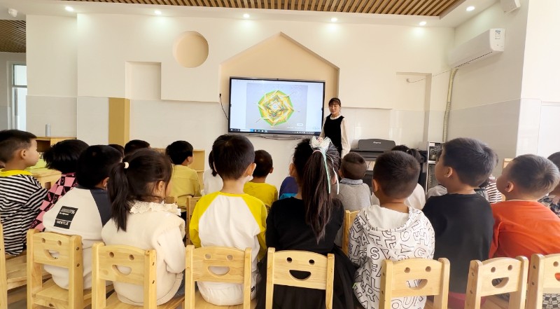 图1：2023年10月10日，在九州实验幼儿园大一班，教师为幼儿介绍不同形式的编织，并讲解了编织方法.jpg